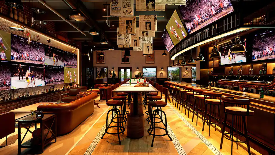 Highlights sports bar at Hyatt Zilara Cancun featuring multiple flat-screen TVs, casual lounge seating, and lively game-day atmosphere.